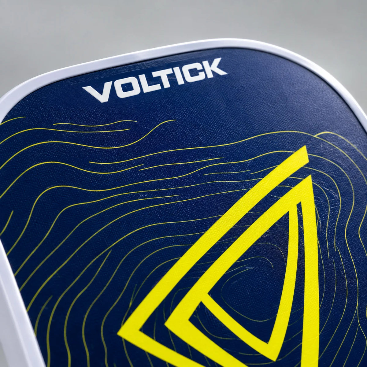 Gros plan sur une raquette de pickleball Voltick bleu nuit et jaune